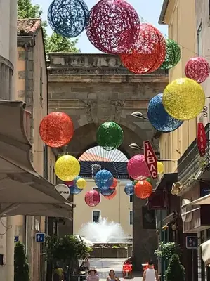 a group of colorful umbrellas hanging over a street at Appartement avec terrasse centre de la Bastide in Carcassonne