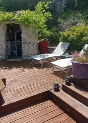 a wooden deck with a bench and a chair at Les oliviers Puisserguier in Puisserguier