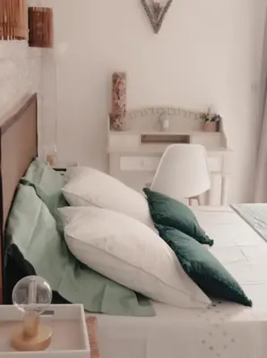 a pile of pillows on a bed in a room at Les oliviers Puisserguier in Puisserguier