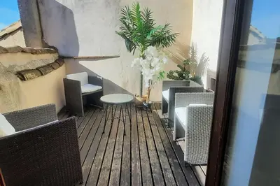a patio with chairs and a table on a balcony at Emplacement N°1+Terrasse Vue+Cité+Trivalle+clim in Carcassonne