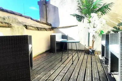 a balcony with a table and chairs on a wooden deck at Emplacement N°1+Terrasse Vue+Cité+Trivalle+clim in Carcassonne