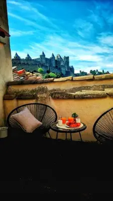 a balcony with two chairs and a table with food on it at Emplacement N°1+Terrasse Vue+Cité+Trivalle+clim in Carcassonne