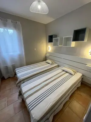 two beds in a room with a window at Chez Francis & Valérie in Villegailhenc