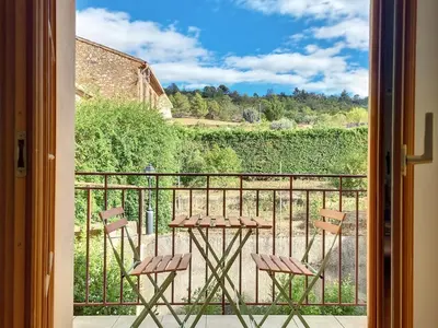 a balcony with two chairs and a table on a porch at Maison sur la place du marché à St Chinian in Saint-Chinian
