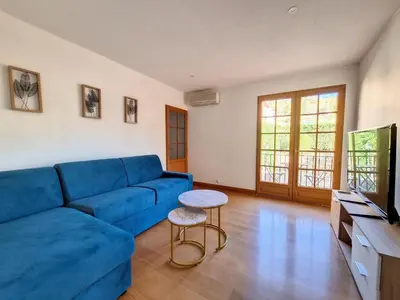 a living room with a blue couch and a table at Maison sur la place du marché à St Chinian in Saint-Chinian