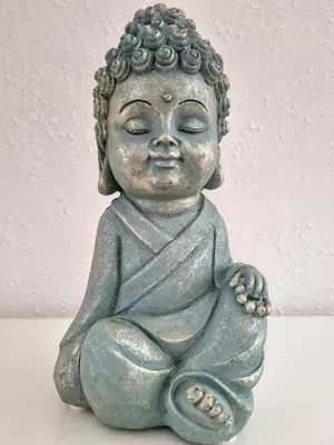 a statue of a little boy sitting down at Maison sur la place du marché à St Chinian in Saint-Chinian