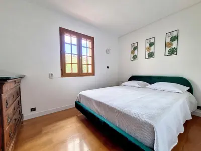 a bedroom with a large bed and a window at Maison sur la place du marché à St Chinian in Saint-Chinian