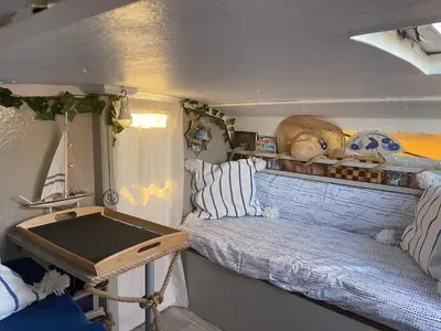 a small room with a bed and a table at Symbiose sur l’eau Gruissan in Gruissan