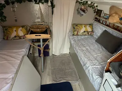 a small room with two beds and a table at Symbiose sur l’eau Gruissan in Gruissan
