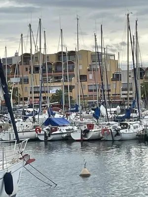 a group of boats docked in a harbor with buildings at Symbiose sur l’eau Gruissan in Gruissan