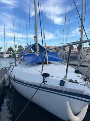 a white sailboat docked at a dock in the water at Symbiose sur l’eau Gruissan in Gruissan