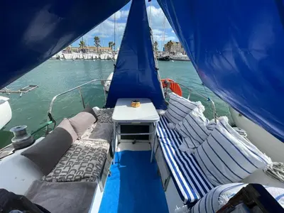 a boat with a bed and a table on a boat at Symbiose sur l’eau Gruissan in Gruissan