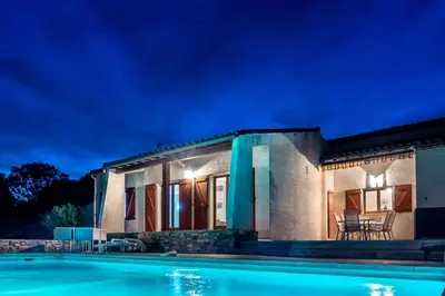 a villa with a swimming pool at night at villa queen-south IT in Ventenac-Cabardès
