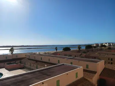 a group of buildings with the ocean in the background at Appartement avec magnifique vue sur mer in Gruissan