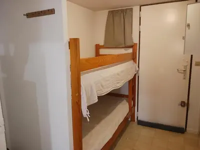 a small room with a bunk bed and a closet at Appartement avec magnifique vue sur mer in Gruissan