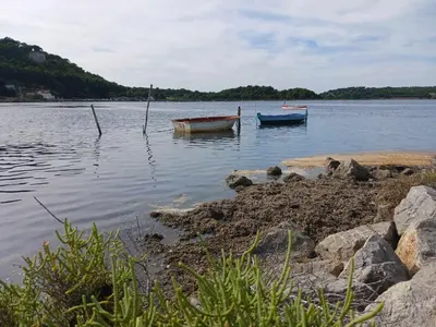 two boats sitting in the water on a lake at Appartement avec magnifique vue sur mer in Gruissan