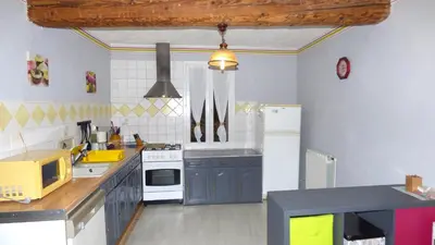 a kitchen with blue cabinets and a white refrigerator at Gîte Les Mimosas in Prugnanes
