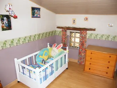 a baby room with a crib with a crib at Gîte Les Mimosas in Prugnanes