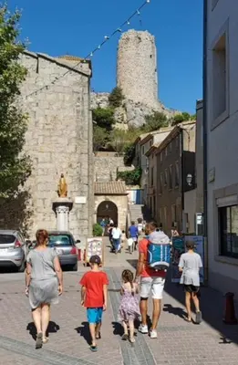 a group of people walking down a street with a castle at VILLA DU PIN in Gruissan