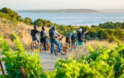 a group of people riding bikes down a dirt road at VILLA DU PIN in Gruissan