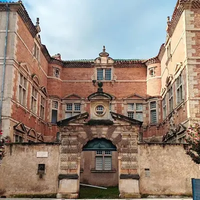 a large brick building with an arch entrance at Appartement Bulle d'antan en cœur de ville - Monument classé historique - Grand Jaccuzi in Castres