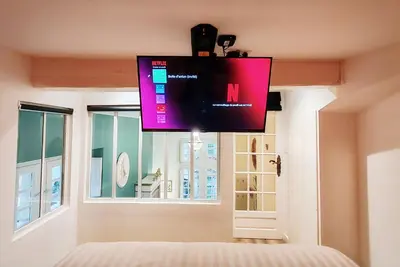 a flat screen tv hanging above a bed in a bedroom at Appartement Bulle d'antan en cœur de ville - Monument classé historique - Grand Jaccuzi in Castres