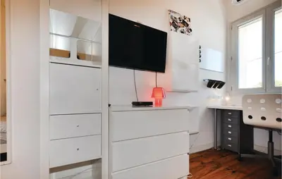 a room with white drawers and a tv on a wall at 4 Bedroom Awesome Home In Narbonne in Narbonne