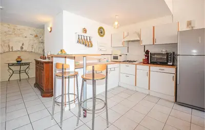 a kitchen with white cabinets and bar stools at Holiday Home Cessenon Sur Orb Mn-1265 in Cessenon