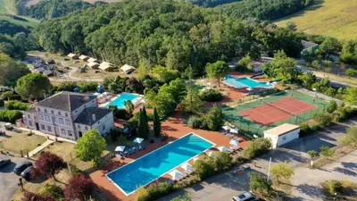 an aerial view of a resort with a tennis court at Mobil Home XXL 4 chambres - Camping Tarn - Domaine du Koukano in Maurens-Scopont