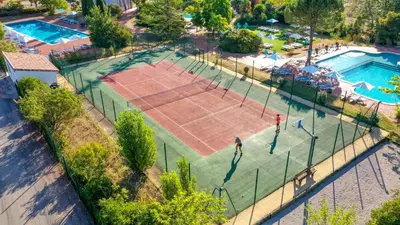 an overhead view of a tennis court with two people on it at Mobil Home XXL 4 chambres - Camping Tarn - Domaine du Koukano in Maurens-Scopont