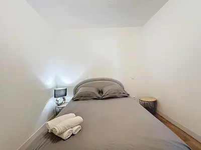 a bedroom with a bed with two towels on it at Le Cocon - Wifi - Cour privative - Proche Halles in Narbonne