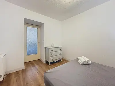 a bedroom with a bed and a dresser and a window at Le Cocon - Wifi - Cour privative - Proche Halles in Narbonne