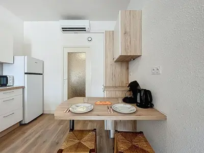 a kitchen with a wooden table with plates on it at Le Cocon - Wifi - Cour privative - Proche Halles in Narbonne