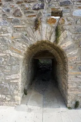 a stone wall with an archway in a building at Le Moulin du plô du Roy in Villeneuve-Minervois