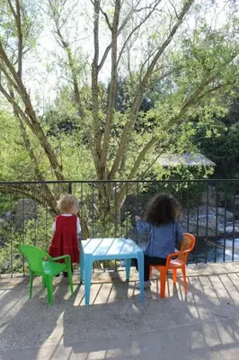 two dolls sitting at a table in chairs at Le Moulin du plô du Roy in Villeneuve-Minervois
