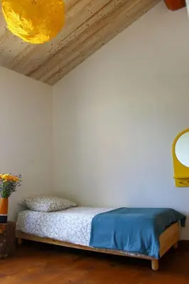 a bedroom with a bed in a room with a ceiling at Le Moulin du plô du Roy in Villeneuve-Minervois