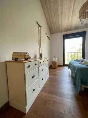 a bedroom with a bed and a dresser with a van on it at Le Moulin du plô du Roy in Villeneuve-Minervois