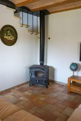 a room with a stove in the corner of a room at Le Moulin du plô du Roy in Villeneuve-Minervois