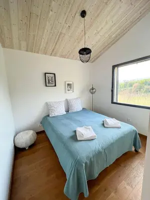 a bedroom with a bed with two towels on it at Le Moulin du plô du Roy in Villeneuve-Minervois