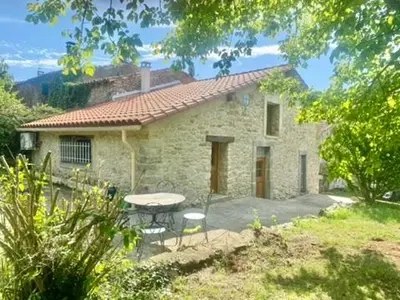 a stone house with a table and chairs in front of it at Maison Tulipe in Puivert