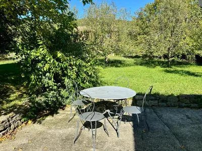 a table and two chairs and a table and a field at Maison Tulipe in Puivert