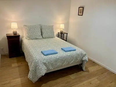 a bedroom with a bed with two blue pillows on it at Maison Tulipe in Puivert