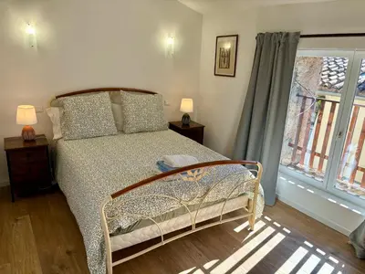 a bedroom with a bed and a window at Maison Tulipe in Puivert