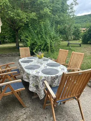a table with four chairs around it with a vase on it at Maison Tulipe in Puivert