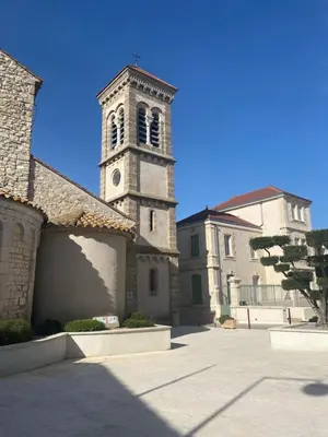 a church with a tower with a clock on it at Charmant Studio in Vinassan