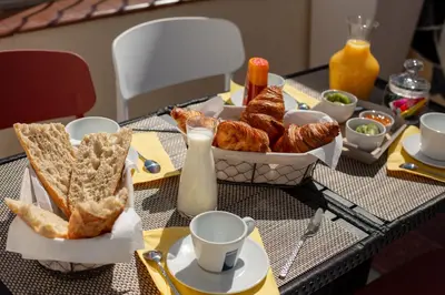 a table with a tray of pastries and croissants on it at Face Cité - Chambres D'Hôtes - Parking & Garage Gratuit - Wi-Fi Gratuit in Carcassonne