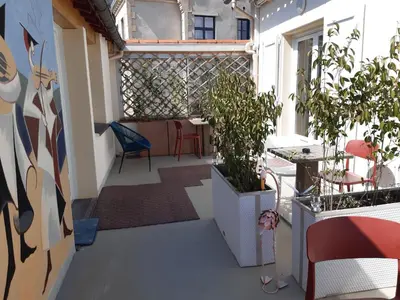 a balcony with plants and a table and chairs at Face Cité - Chambres D'Hôtes - Parking & Garage Gratuit - Wi-Fi Gratuit in Carcassonne