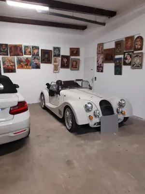 a white car is parked in a garage at Face Cité - Chambres D'Hôtes - Parking & Garage Gratuit - Wi-Fi Gratuit in Carcassonne