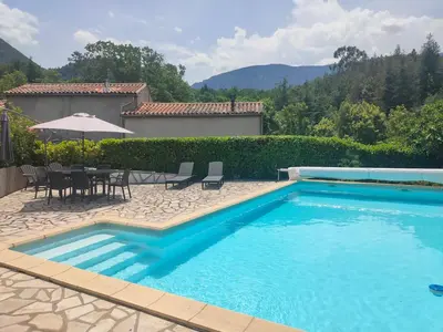 a swimming pool with a table and chairs and an umbrella at Coste de Laval in Quillan