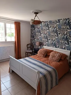 a bedroom with a large bed with a blue and white patterned wall at Coste de Laval in Quillan